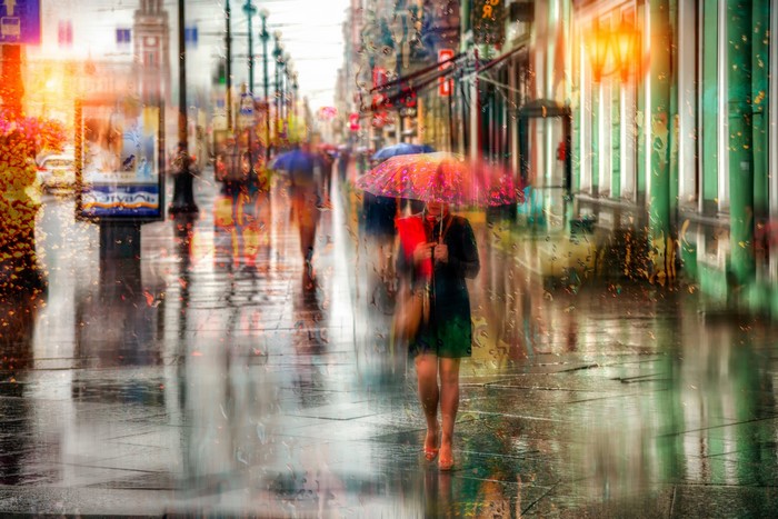 Woman with umbrella on Nevsky Prospect in St. Petersburg during rain