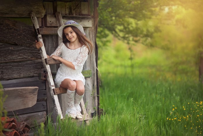 Girl in white dress and hat on a ladder