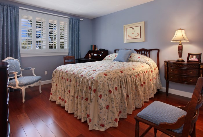 Bedroom with floral bedspread and antique furniture