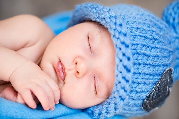 Baby sleeping in a blue winter hat
