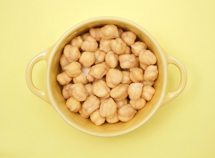 Bowl of chickpeas on a yellow background