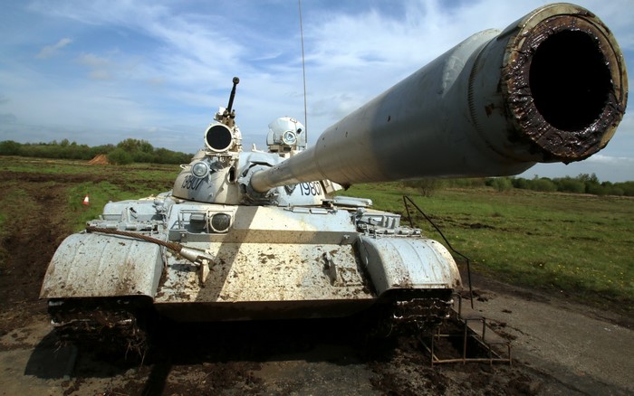 T-55 tank with large gun barrel in muddy field