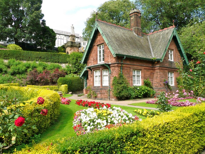 Brick cottage with a manicured garden and statue