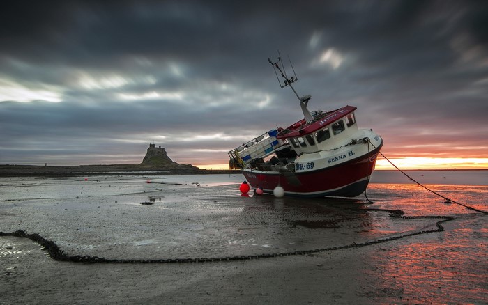 Fishing boat Jenna H. grounded on shore with Lindisfarne Castle in background