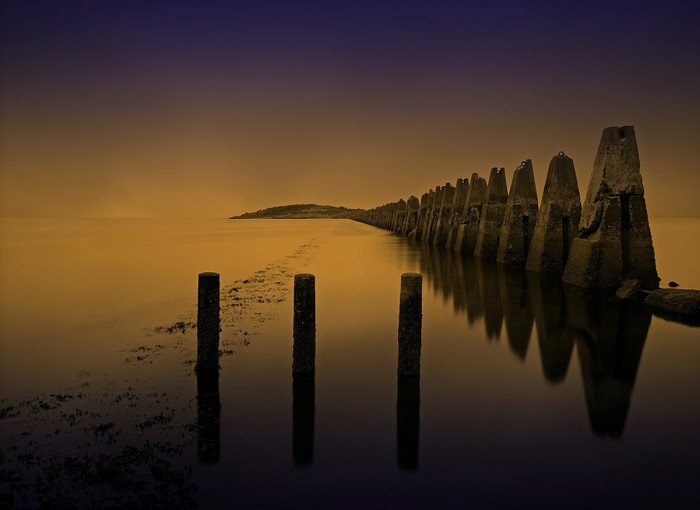 Concrete breakwater and posts in the sea at Cramond, Scotland