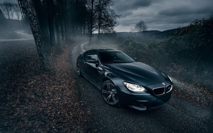 Dark BMW M6 on a foggy road at night