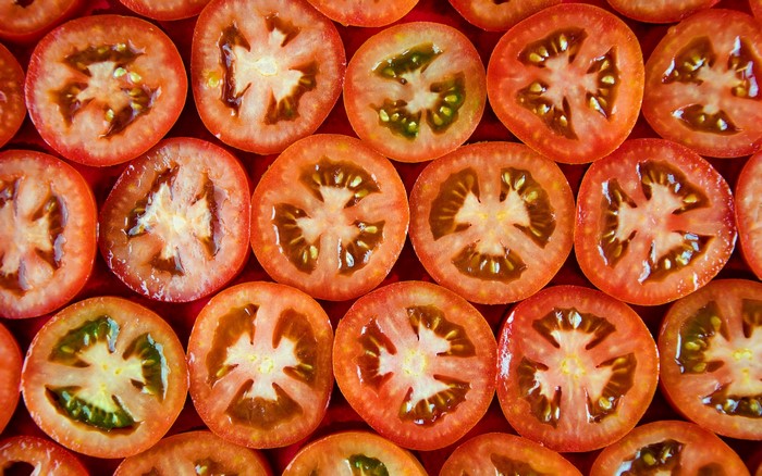 Close-up of sliced tomatoes on a red surface