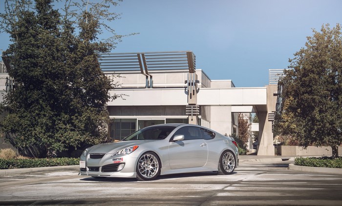 Silver Hyundai Genesis Coupe parked in front of a modern building