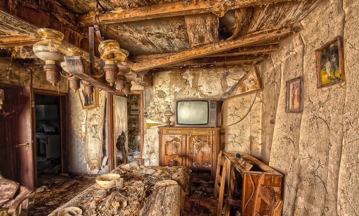 Abandoned room with old TV and chandelier