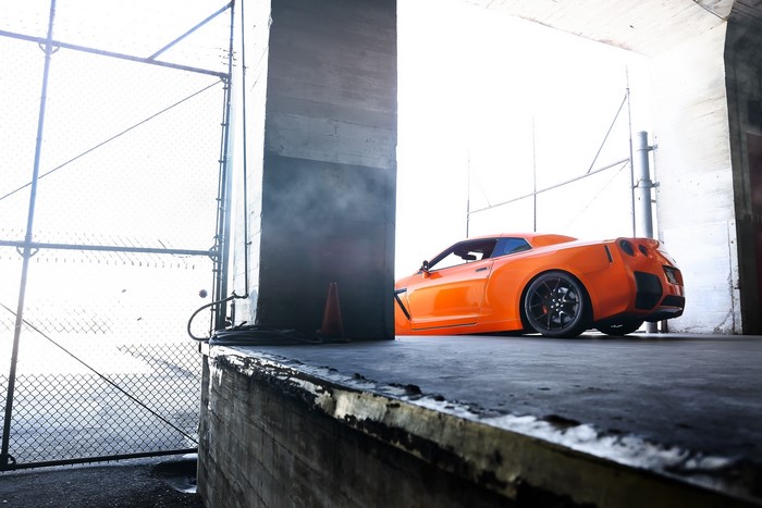Orange Nissan GT-R R35 parked in a concrete structure