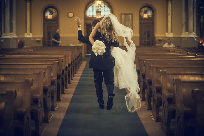 Bride and Groom walking down church aisle