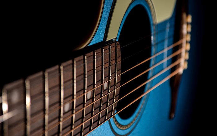 Closeup of a blue acoustic guitar fretboard