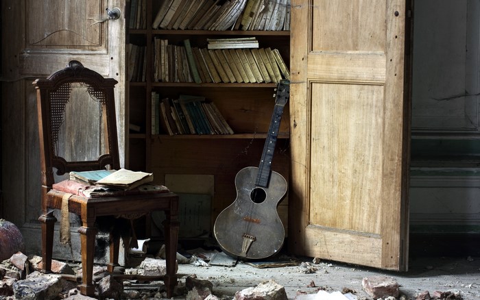 Old chair and guitar in a derelict room