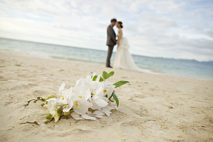 Wedding couple on a beach with bouquet