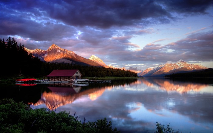 Mountain lake with boathouse at sunset