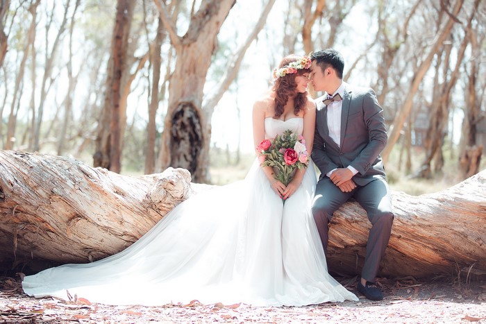 Bride and Groom sitting on a log