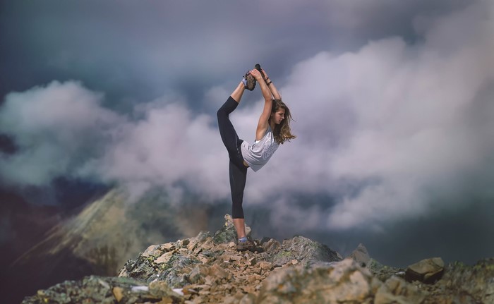 Woman Stretching on Rocky Mountain Peak