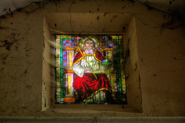 Stained glass window of Jesus with a globe and scepter