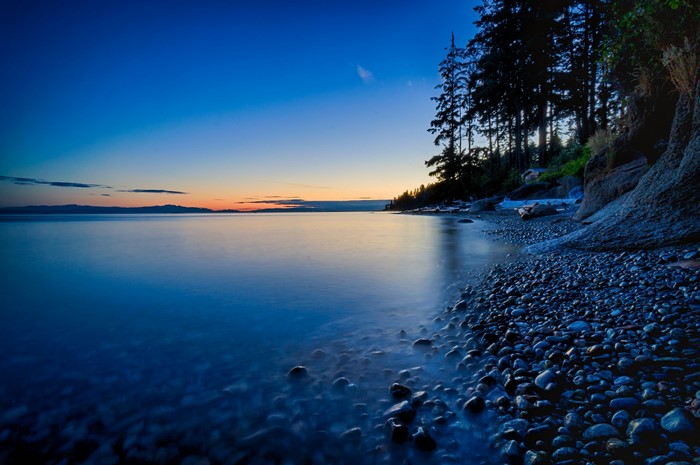 Rocky Shoreline at Dusk with Calm Water
