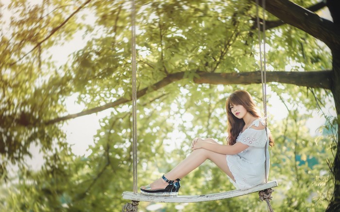 Asian girl with brown hair on a swing
