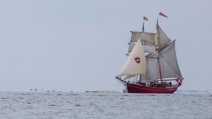 Red sailing ship with white sails on the sea