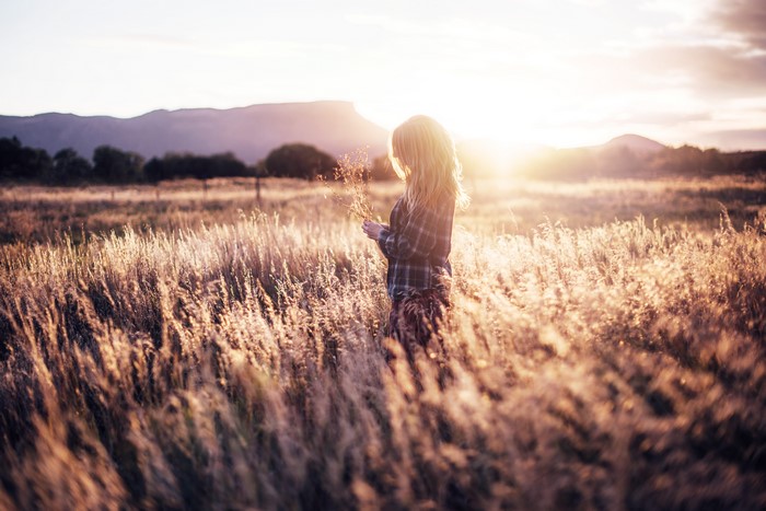 Woman in a field at sunset