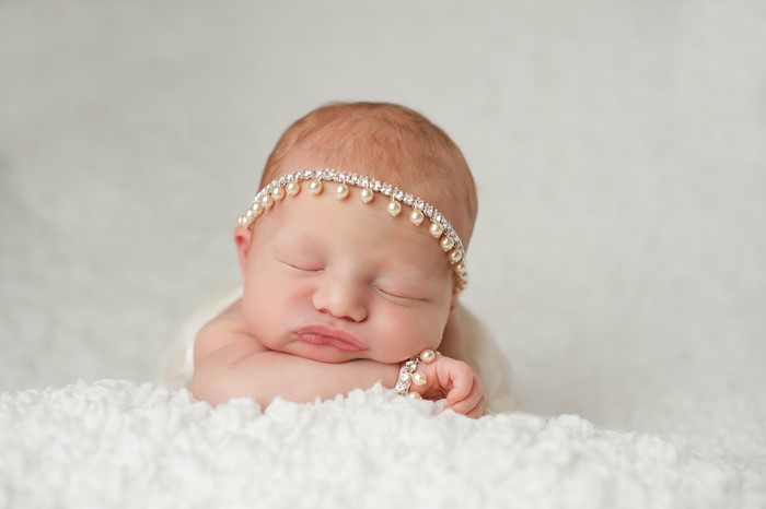 Newborn baby girl wearing a pearl headband