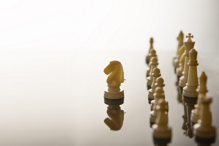 White chess pieces on a reflective surface