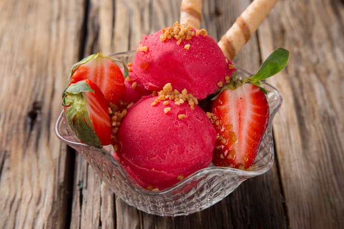 Strawberry ice cream with wafer sticks and fresh strawberries