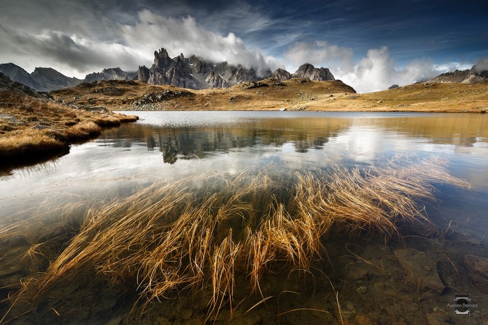 Mountain lake with submerged grass and rocky peaks