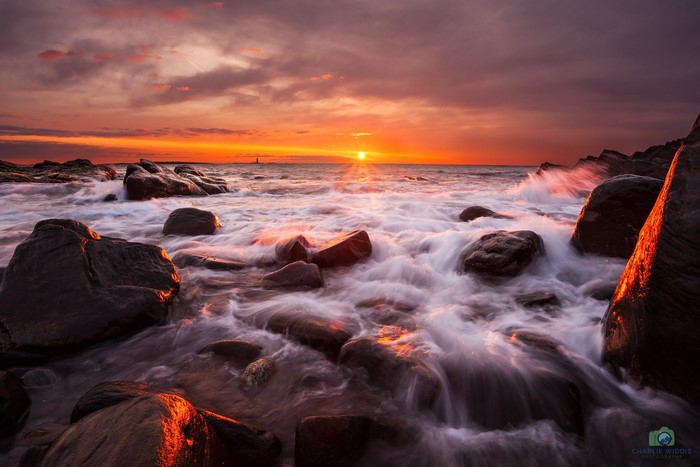 Sunset over the sea with rocks and waves in Scotland