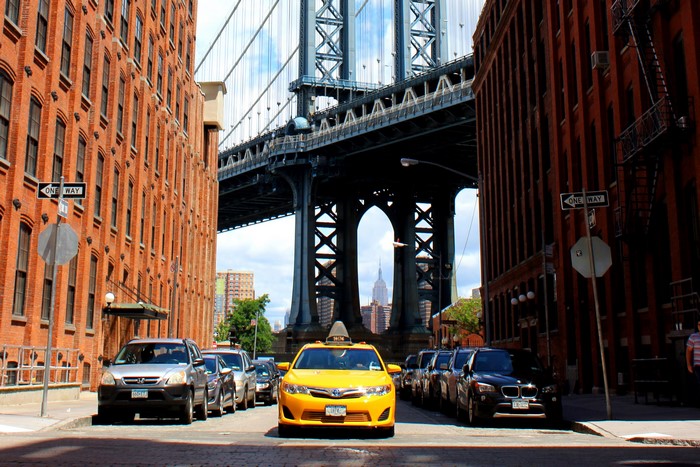 Yellow taxi and cars under Manhattan Bridge, New York City