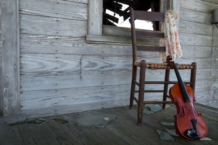 Violin on a chair on a porch