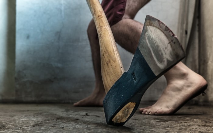 Man with axe standing on concrete floor