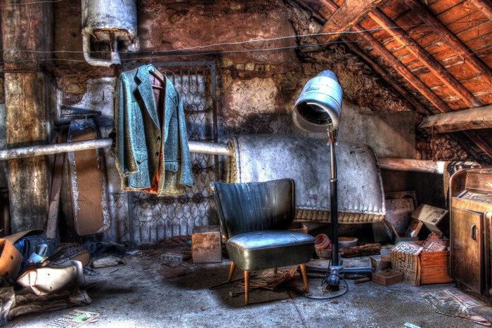 Abandoned attic with vintage hair dryer and chair