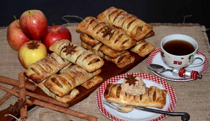 Apple pastries with tea and cinnamon sticks
