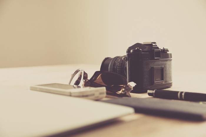 Camera, glasses, and phone on a table
