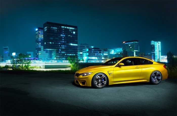 Yellow BMW F82 M4 parked at night in Germany