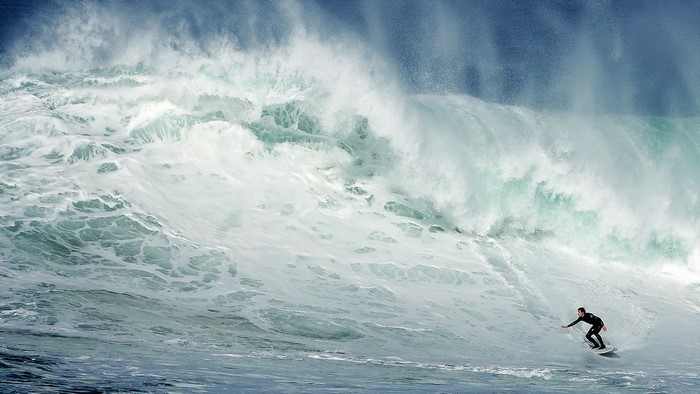 Surfer riding a massive wave