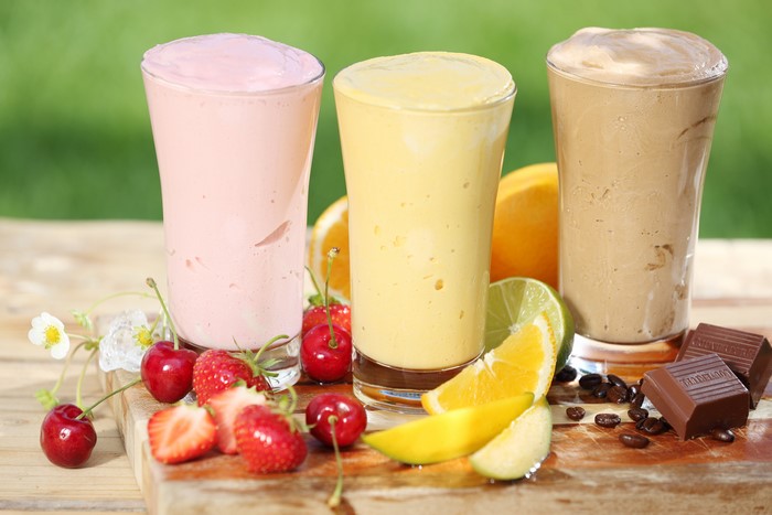 Three colorful milkshakes with fruits and chocolate