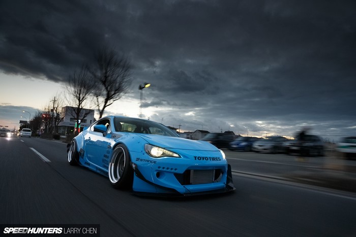 Blue Toyota GT86 with widebody kit driving on road