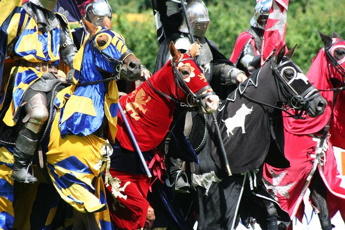 Knights in armor on horseback with colorful banners