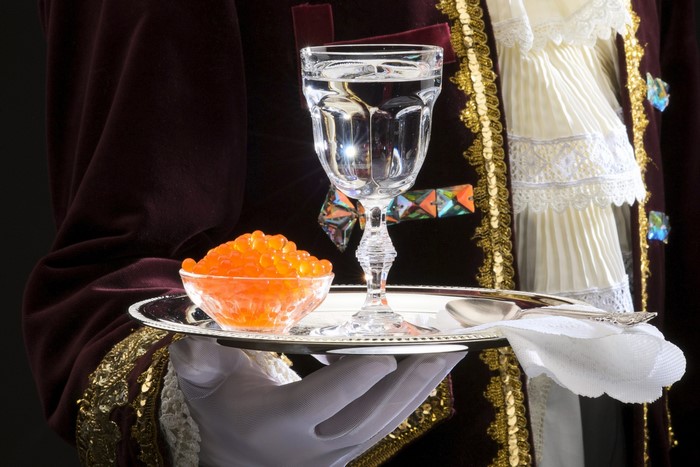 Waiter serving caviar and vodka