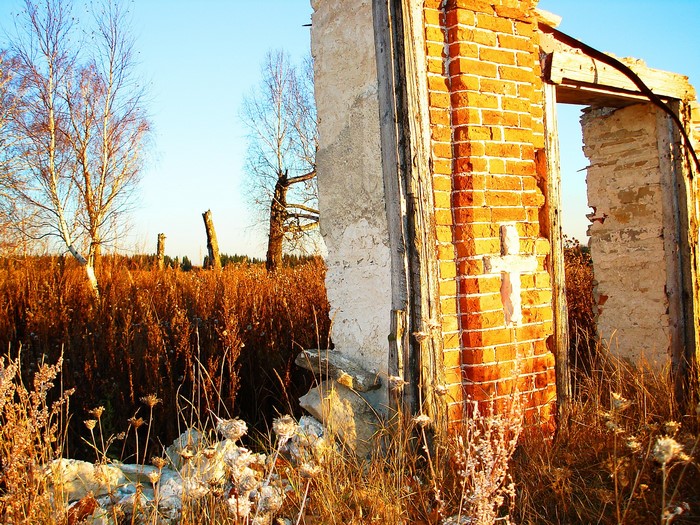 Ruins with a cross in autumn field