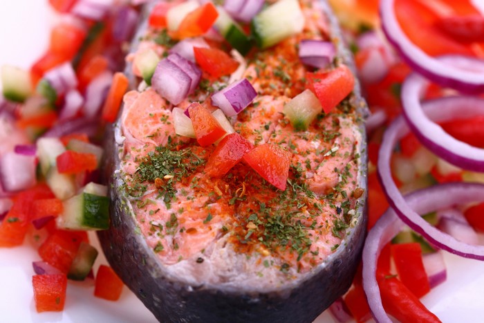 Salmon steak with chopped vegetables and red onion rings