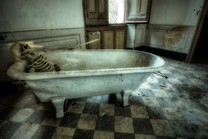 Skeleton in a bathtub in an abandoned bathroom