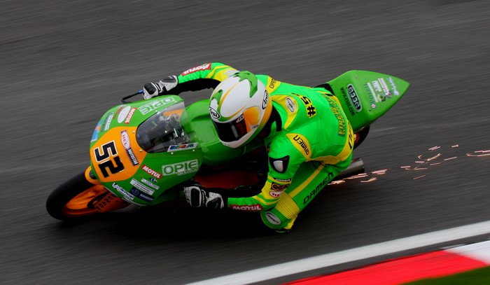 Motorcyclist #52 in green and yellow racing suit