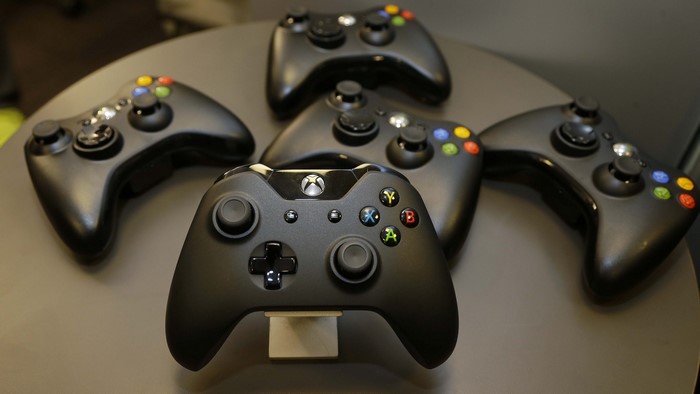 Multiple black Xbox controllers on a table