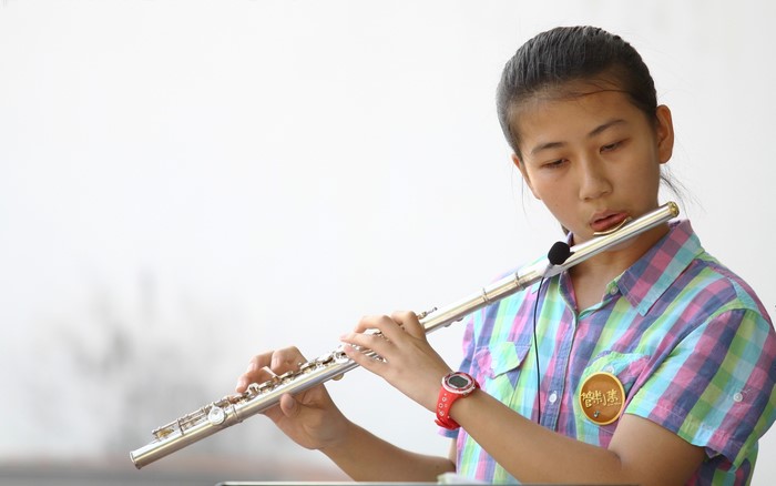 Young Asian girl playing a flute