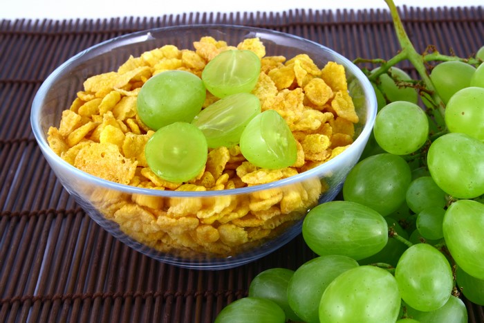 Corn flakes and green grapes in a bowl
